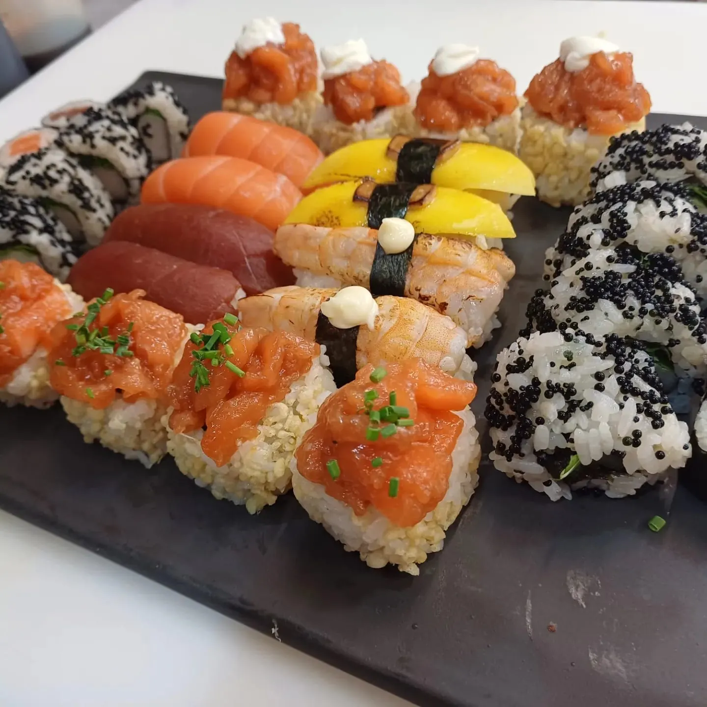 Surtido de nigiri y uramaki de Kurama sobre pizarra